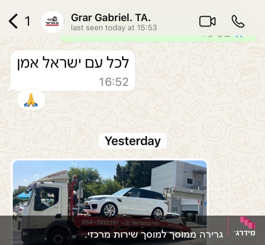 משאית גרירה עם רכב לבן על הכביש